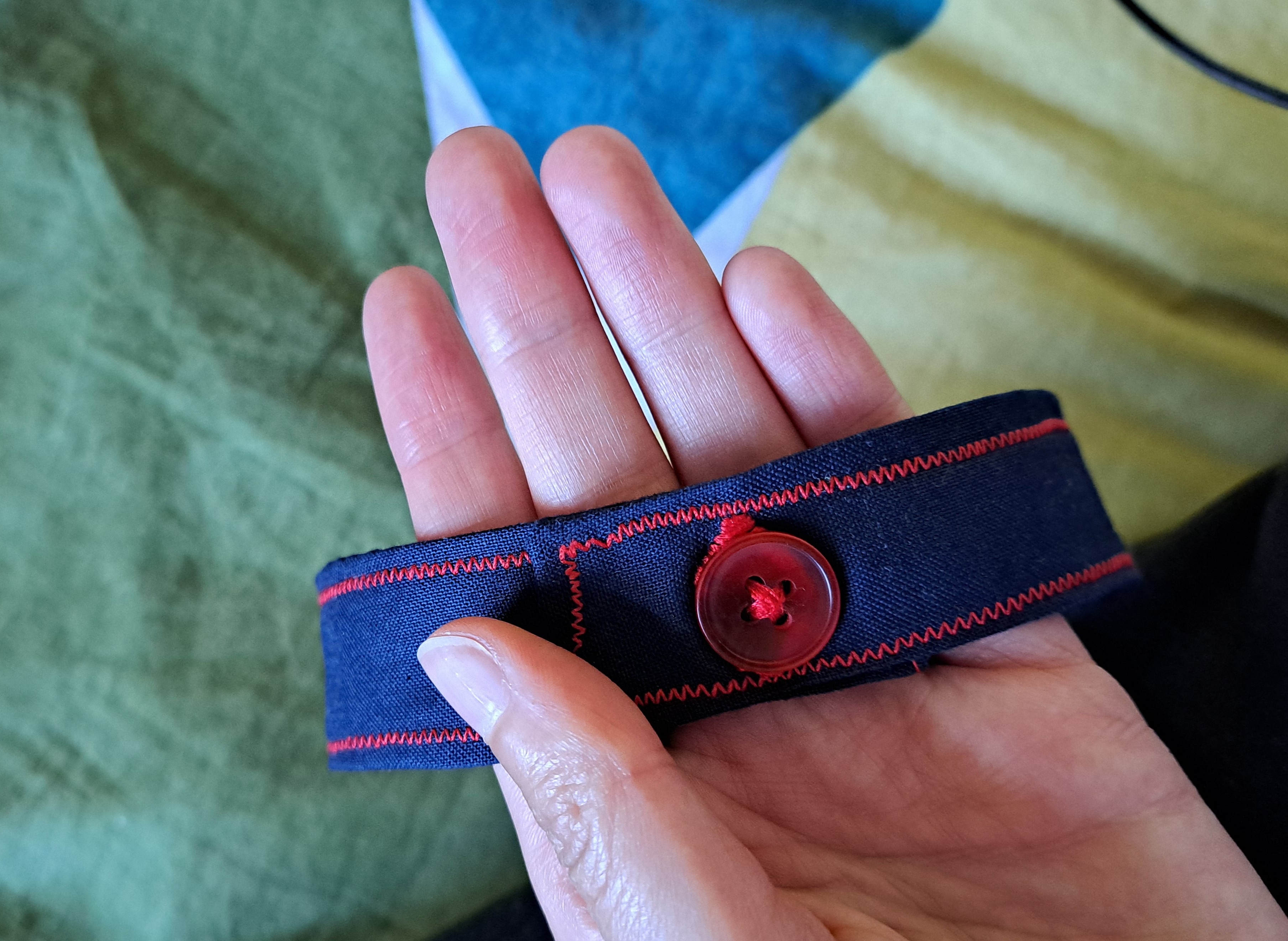 buttonhole stitched in red thread on navy fabric