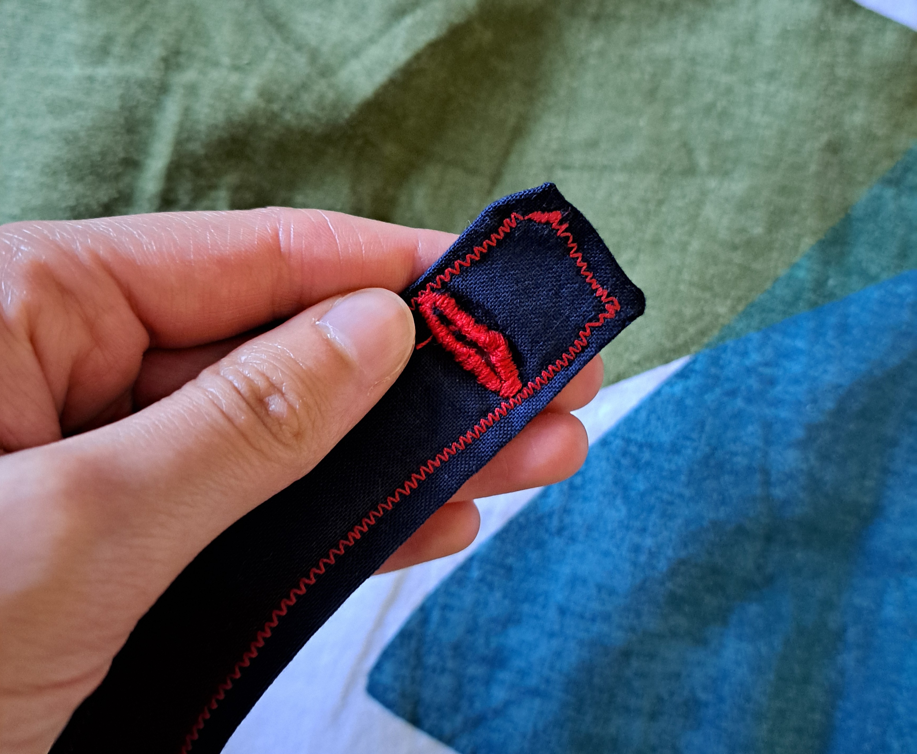 buttonhole stitched in red thread on navy fabric